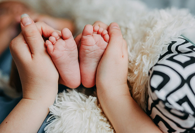Moeder houdt kindervoetjes vast