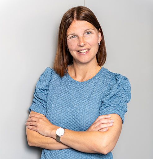 Linda met armen over elkaar in kantoor