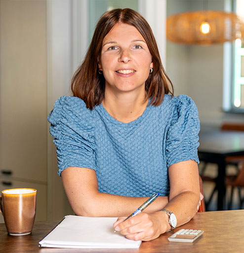 Linda Heijmans op kantoor met rekenmachine naast haar